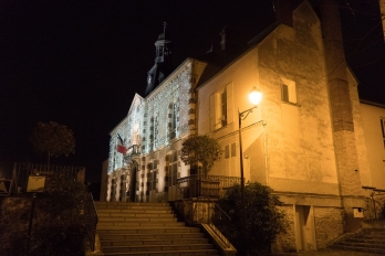Mairie de jouy-le-Moutier, vue de côté en contre-bas du bâtiment, éclairée, de nuit