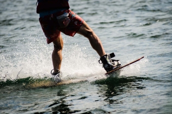 Zoom sur les jambes d'un homme qui fait du téléski nautique en short