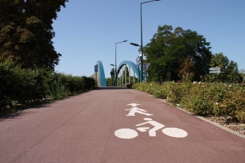 Piste cyclable et voie piétonne à Neuville-sur-Oise avec les arches bleues du pont en arrière-plan
